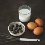 Aveia, ovos, leite e frutas sobre uma mesa, ilustrando alimentação para iniciantes na academia