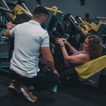 Personal Trainer orientando aluno durante atendimento em academia