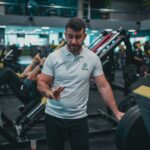 Personal Trainer em atendimento na academia, representando planejamento e precificação do serviço