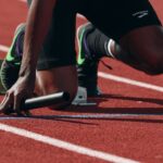 Atleta correndo em pista durante monitoramento de carga de treinamento