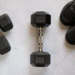 Halteres e tênis esportivos representando equipamentos para treino em casa