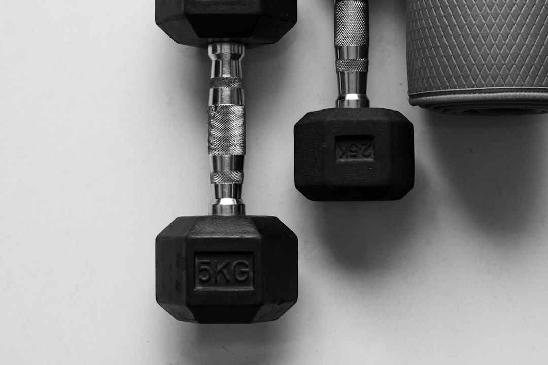 Halteres e colchonete de exercícios representando preparação para o treino