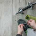 Tênis, halteres e garrafa de água organizados para treino de academia