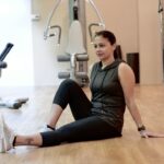 Pessoa sentada no chão realizando movimento de alcance anterior para avaliação de flexibilidade